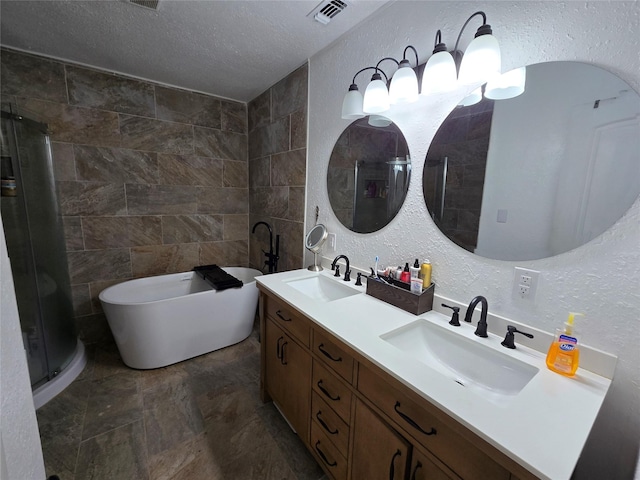 full bathroom featuring double vanity, a freestanding tub, visible vents, and a sink