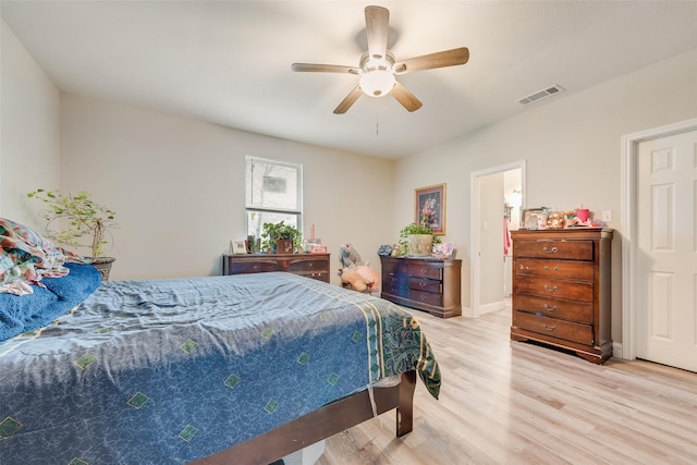 bedroom featuring light wood finished floors, baseboards, visible vents, and a ceiling fan