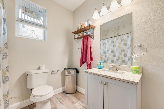 bathroom with toilet, wood finished floors, vanity, baseboards, and a shower with curtain