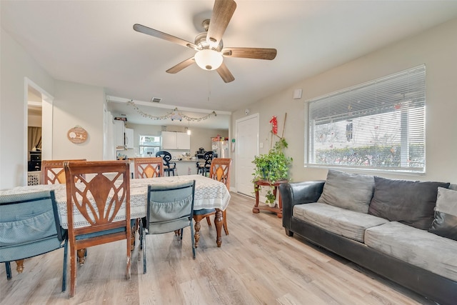 dining area featuring visible vents, plenty of natural light, a ceiling fan, and light wood-style floors