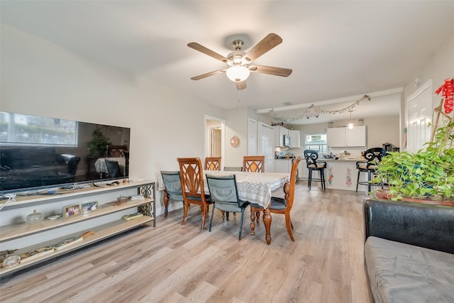 dining room with light wood-style flooring and a ceiling fan