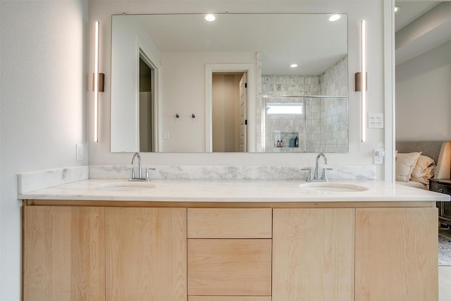 bathroom with double vanity, a stall shower, and a sink