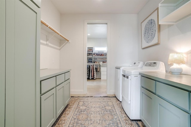 laundry room featuring cabinet space, baseboards, and washer and clothes dryer