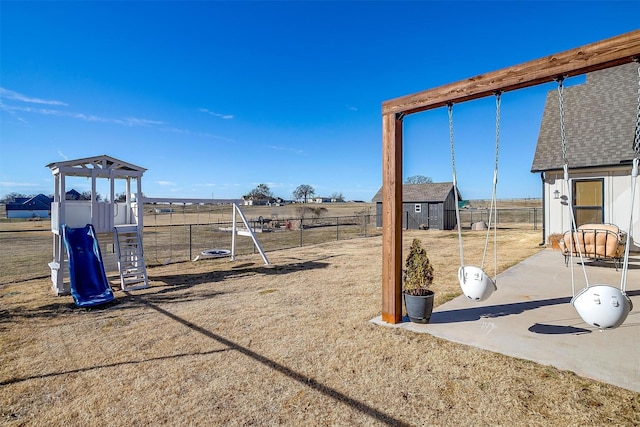 view of jungle gym featuring a storage unit, a patio area, fence, and an outdoor structure