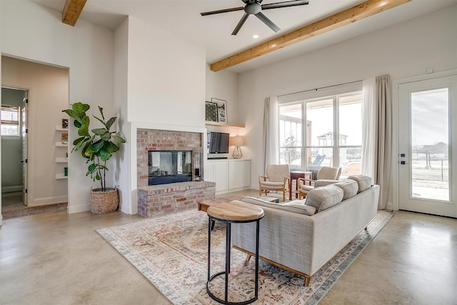 living room with finished concrete floors, a brick fireplace, and beamed ceiling