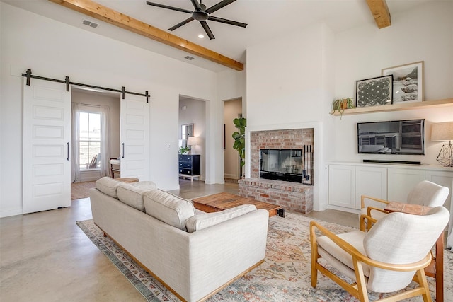 living room with beam ceiling, a fireplace, a barn door, finished concrete floors, and ceiling fan