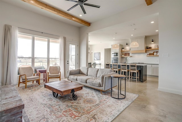 living room featuring finished concrete flooring, recessed lighting, beam ceiling, and baseboards