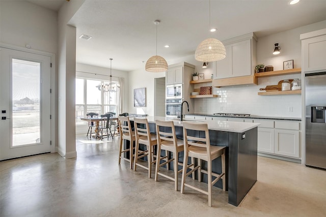 kitchen featuring open shelves, appliances with stainless steel finishes, hanging light fixtures, and white cabinets