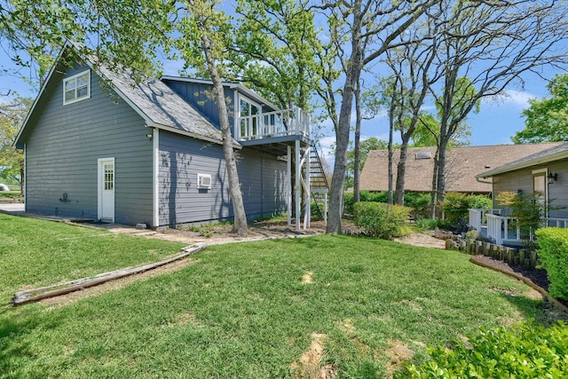 rear view of house with a deck, roof with shingles, stairway, a lawn, and board and batten siding