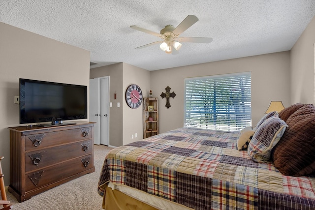 bedroom with a ceiling fan, a textured ceiling, and light colored carpet