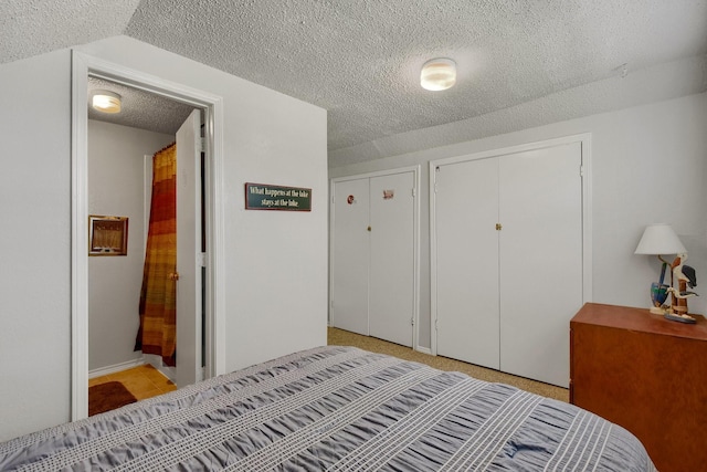 bedroom featuring a textured ceiling and two closets