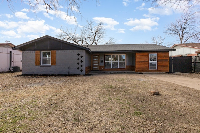 view of front of property with brick siding and fence