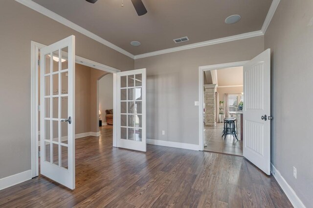 unfurnished room featuring ornamental molding, arched walkways, french doors, and dark wood-style flooring