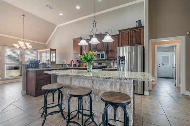 kitchen with tasteful backsplash, a kitchen island, a peninsula, stainless steel appliances, and crown molding