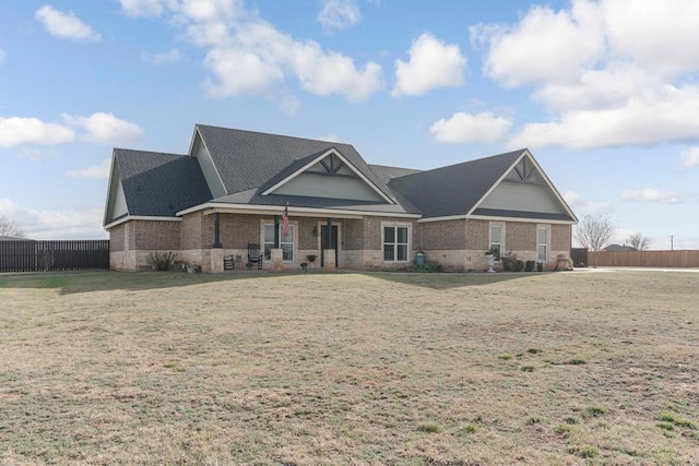 view of front of property with fence, a front lawn, and brick siding