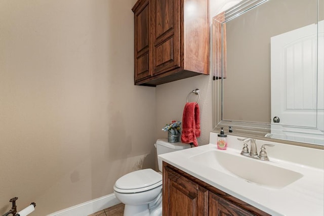 bathroom with tile patterned flooring, vanity, toilet, and baseboards