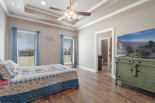 bedroom featuring ornamental molding, a raised ceiling, visible vents, and wood finished floors