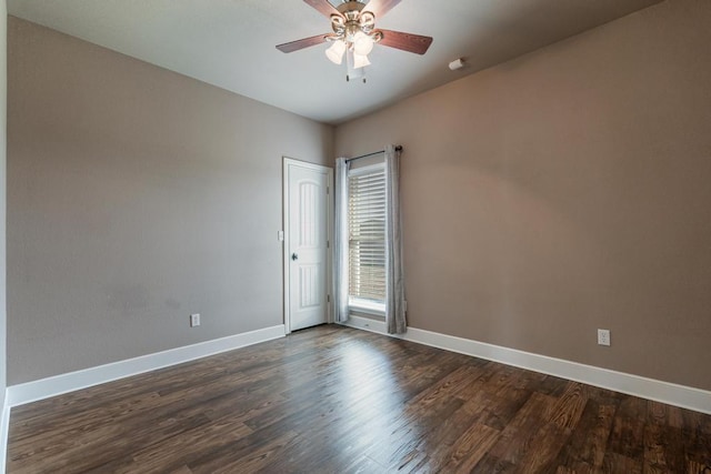 unfurnished room with dark wood-style floors, ceiling fan, and baseboards