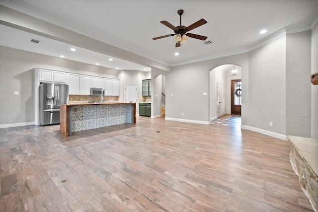 kitchen featuring visible vents, arched walkways, stainless steel appliances, and open floor plan