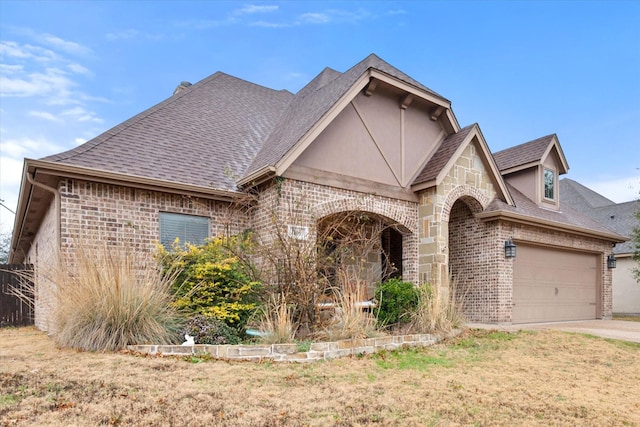 view of front of home featuring an attached garage, brick siding, and a shingled roof