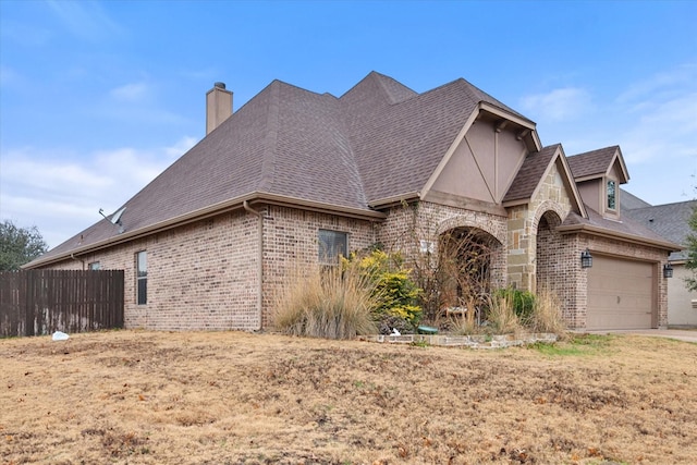 view of front of house featuring brick siding, a shingled roof, a chimney, and fence