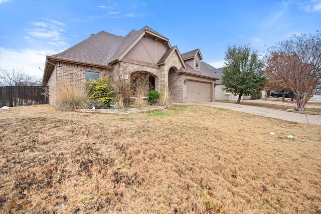 view of front of property featuring roof with shingles, a front lawn, driveway, a garage, and brick siding