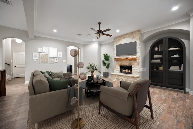 living area with visible vents, recessed lighting, a ceiling fan, hardwood / wood-style flooring, and a stone fireplace