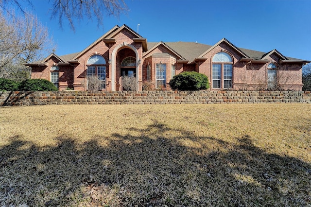 view of front of property with a front lawn and brick siding