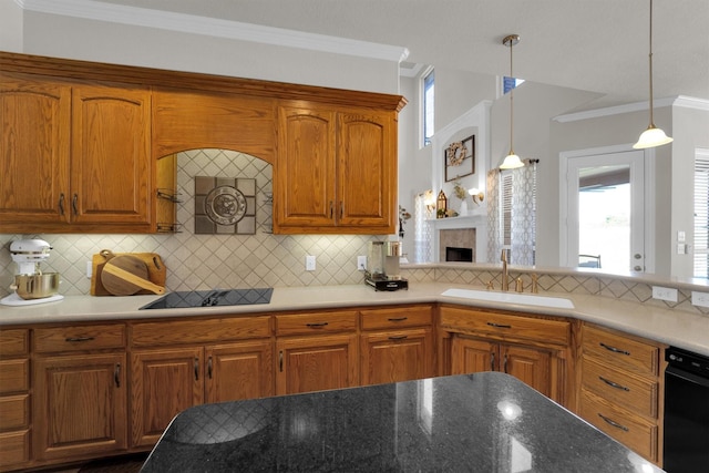 kitchen with black appliances, brown cabinetry, a sink, and pendant lighting