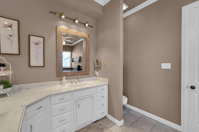 bathroom featuring baseboards, toilet, ornamental molding, tile patterned floors, and vanity