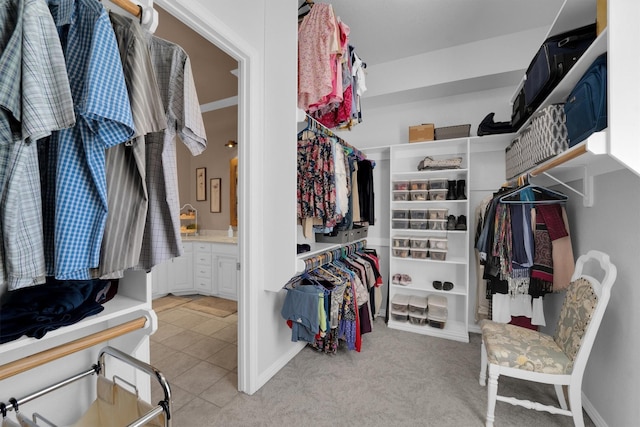 spacious closet featuring light tile patterned floors and light colored carpet