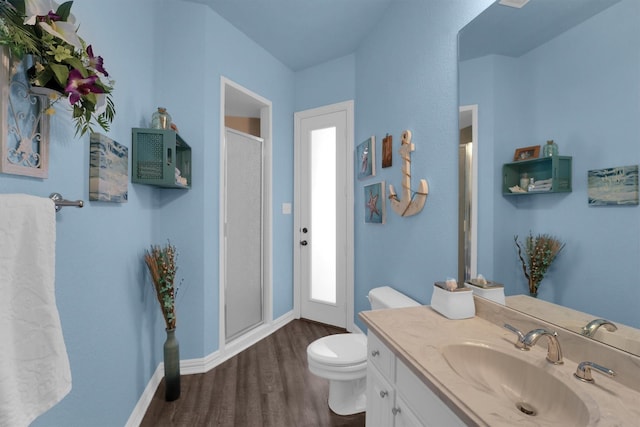 full bath featuring baseboards, toilet, wood finished floors, vanity, and a shower stall