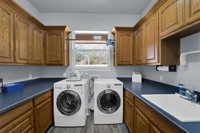 laundry room with cabinet space, dark wood-style flooring, separate washer and dryer, and a sink