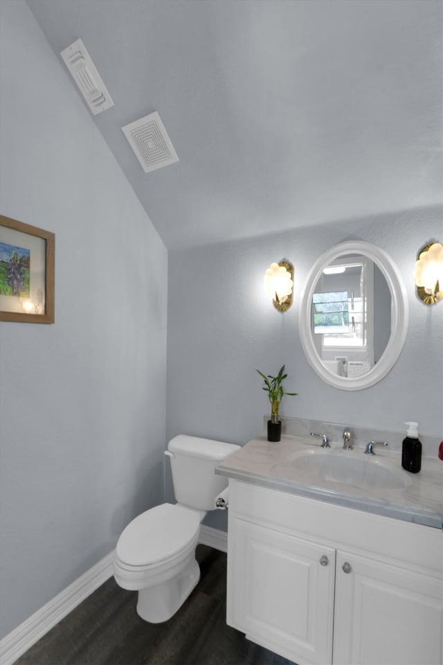 bathroom featuring toilet, visible vents, wood finished floors, and vanity