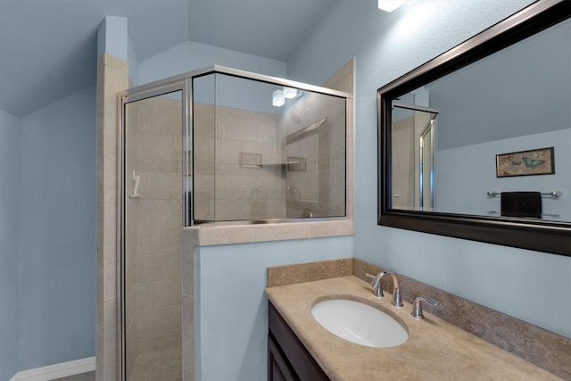 bathroom with a stall shower, vaulted ceiling, and vanity