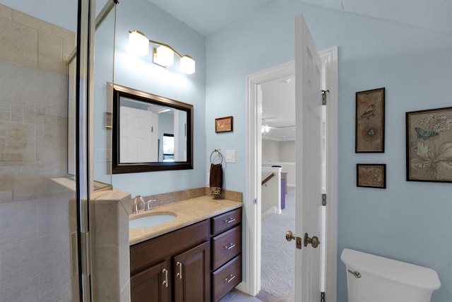 bathroom featuring toilet, a stall shower, and vanity