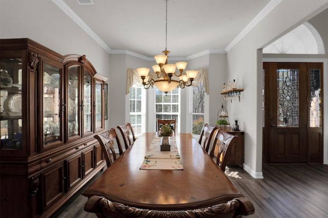 dining space with dark wood-type flooring, ornamental molding, baseboards, and an inviting chandelier