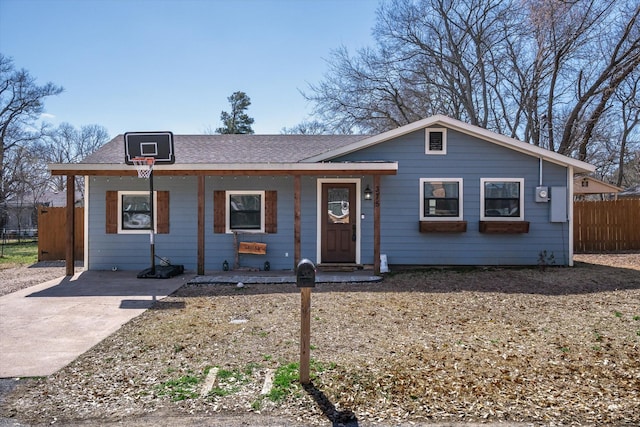 view of front facade with a shingled roof and fence