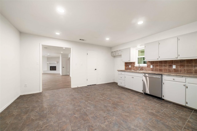 2209 9th St, Brownwood, TX 76801 - kitchen with stainless steel dishwasher, a sink, white cabinetry, recessed lighting, and tasteful backsplash