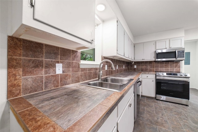 2209 9th St, Brownwood, TX 76801 - kitchen with appliances with stainless steel finishes, a sink, and white cabinets