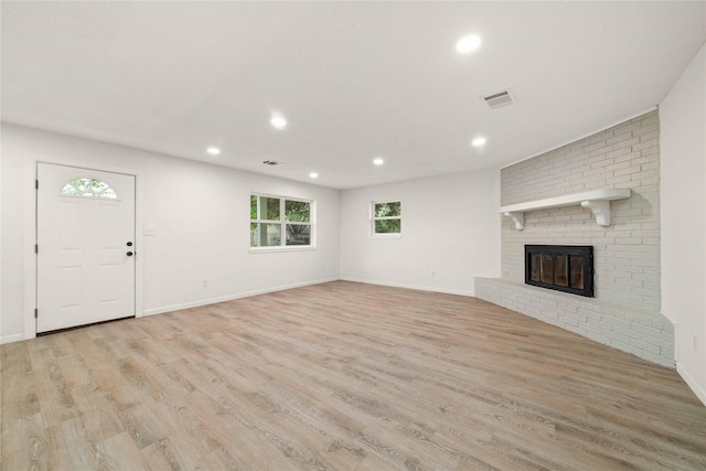 2209 9th St, Brownwood, TX 76801 - unfurnished living room featuring recessed lighting, healthy amount of natural light, light wood finished floors, a fireplace, and baseboards