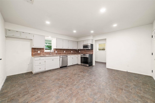 2209 9th St, Brownwood, TX 76801 - kitchen featuring stainless steel appliances, a sink, stone finish flooring, baseboards, and recessed lighting