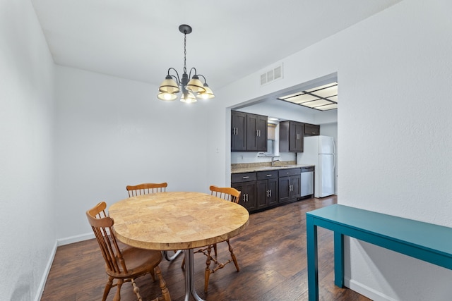 dining room with a chandelier, dark wood-style flooring, visible vents, and baseboards