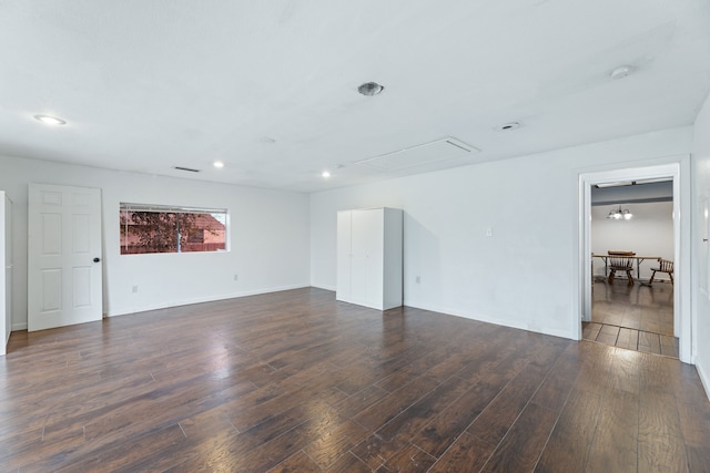 unfurnished room with attic access, recessed lighting, dark wood finished floors, and baseboards