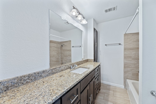 full bath with visible vents, vanity, and baseboards