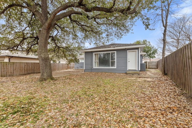 back of property with central air condition unit, a fenced backyard, and entry steps