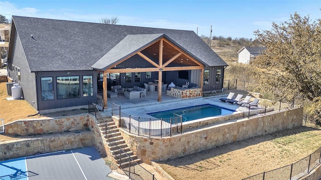 view of pool with an outdoor hangout area, a patio area, stairs, and fence