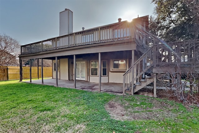 back of property with stairway, fence, a deck, a yard, and a patio area