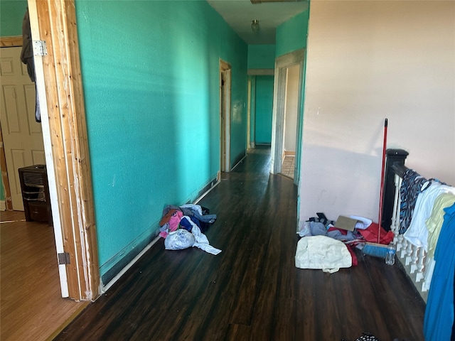 hallway with baseboards and dark wood-type flooring