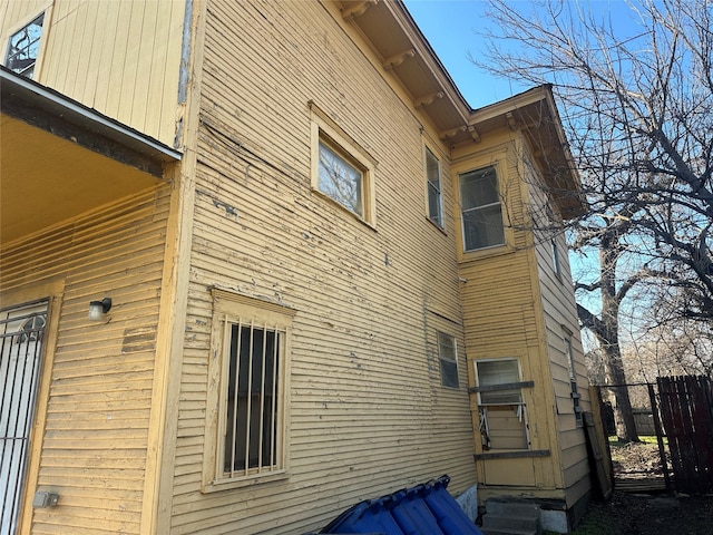 view of side of property with entry steps and fence